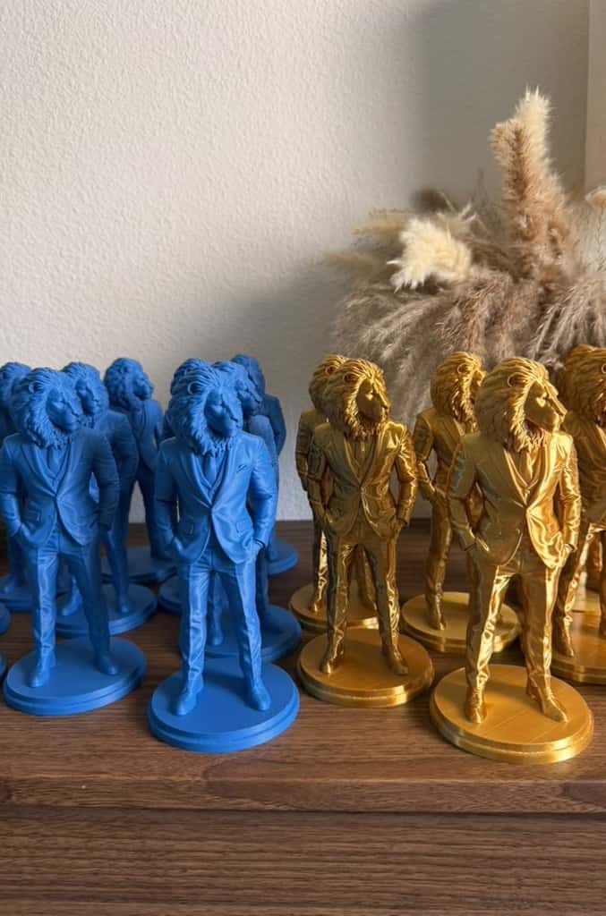 Blue and shiny gold Lion Gentleman sculptures side by side