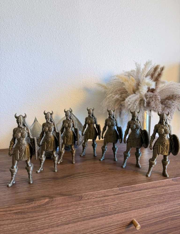 Eleven bronze Viking and Shield Maiden figures lined up on a wooden sideboard