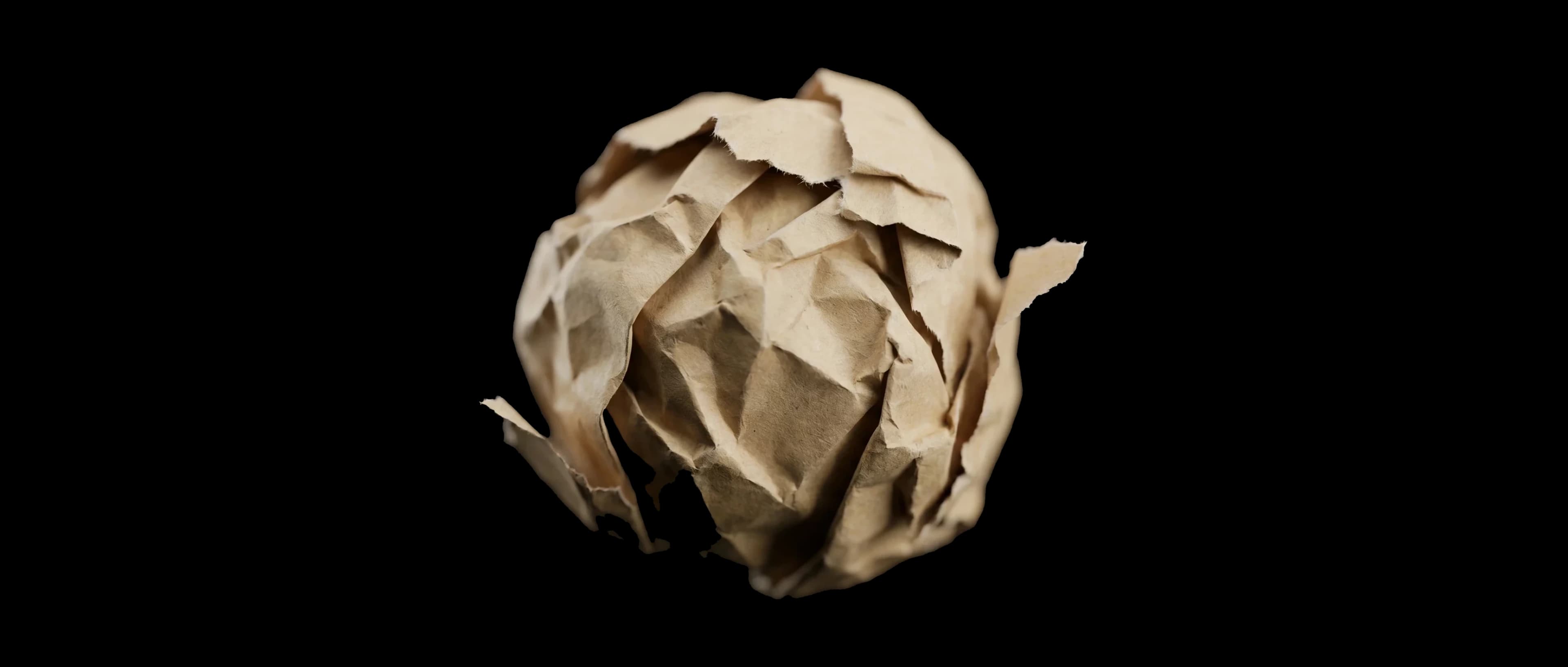 Crumpled paper ball on black — the first sketch of an idea