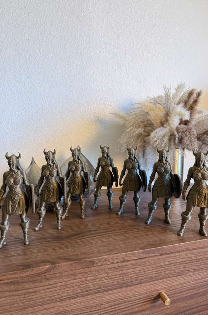 Seven bronze Viking shield-maiden figures in a row